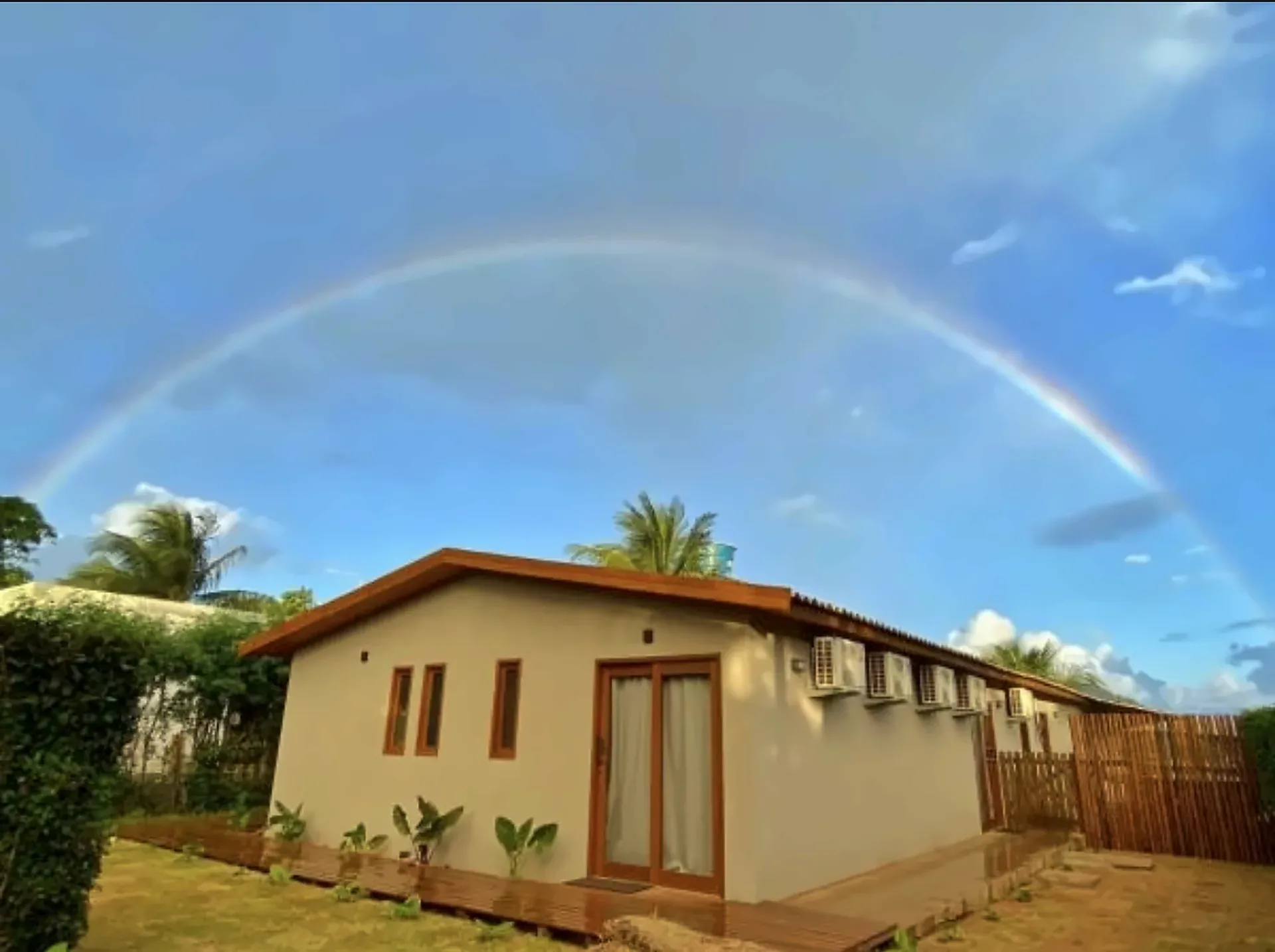 Fachada da Pousada Maresia Noronha com arco-íris no céu de Fernando de Noronha