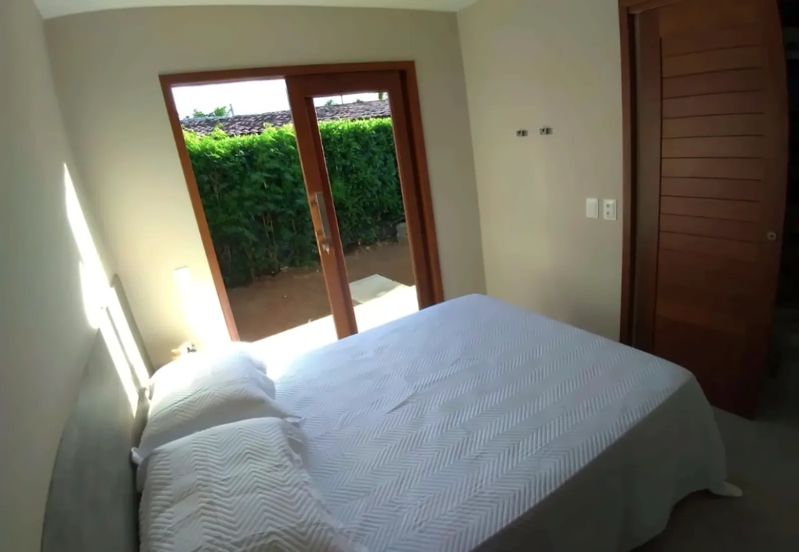 Cama e porta com saída para jardim no Duplo Standard